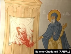 A fresco depicts Georgian monk Gabriel Urgebadze setting fire to a banner of Vladimir Lenin.