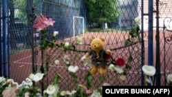 Cveće i igračka na ogradi Osnovne škole "Vladimir Ribnikar" u danima nakon napada, maj 2023.