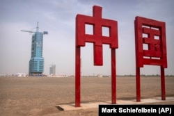 Covered on a launch pad, the Shenzhou-16 spacecraft sits atop a Long March rocket near a sign reading "China" at the Jiuquan Satellite Launch Center in northwest China in May 2023.