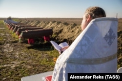Ноябрь 2022 года, Луганская область. Священник во время перезахоронения останков мирных жителей из Северодонецкой агломерации