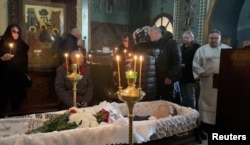 Disa persona afër trupit të vdekur të Navalnyt, gjatë ceremonisë përkujtimore në kishë.