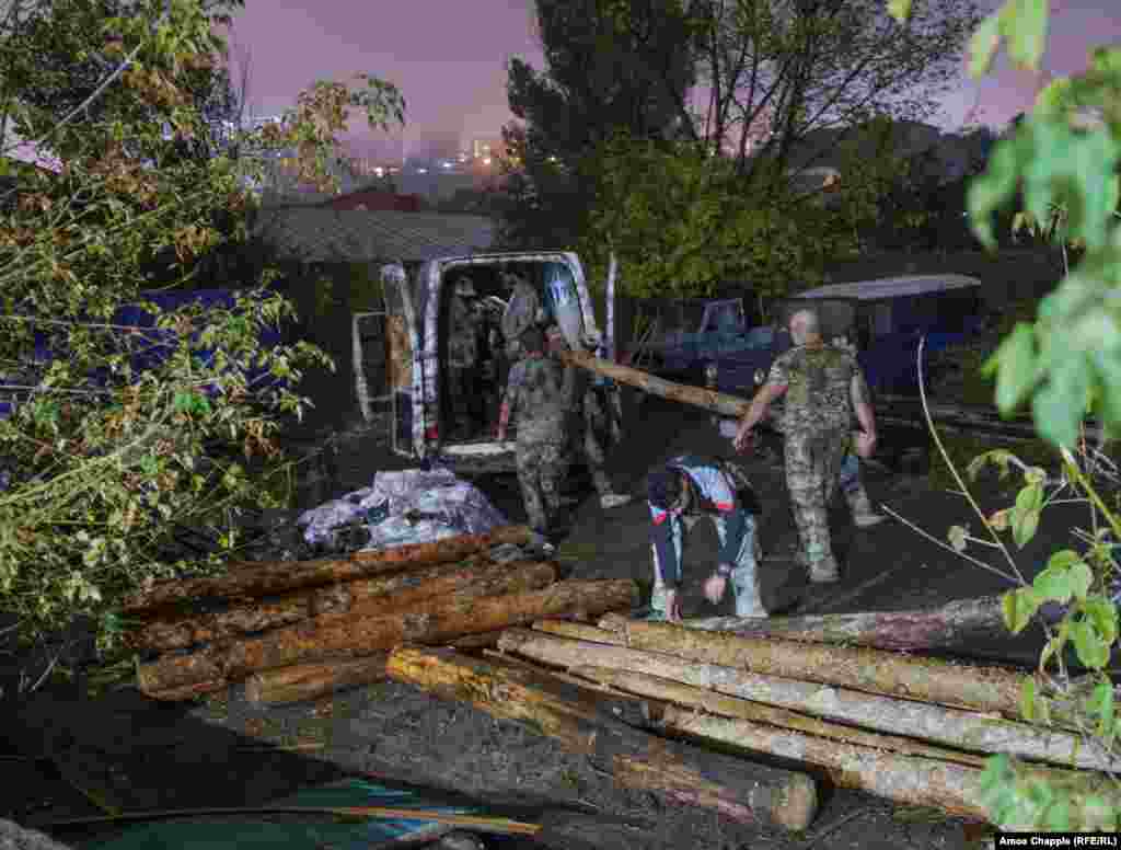 Volunteers load lengths of timber onto a van at the VOMA training center that will be used to construct bunkers. Along with training, VOMA is also currently installing bunkers throughout Armenia that will be used in the event of an invasion. The bunkers are built from earth and timber, and in some cases, used truck tires. The group hopes to install thousands of simple bunkers across the country. &nbsp;