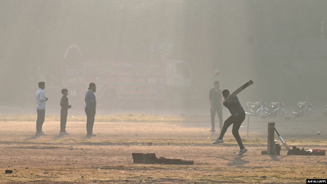 Youths play cricket amid smoggy conditions in Lahore on November 14. 