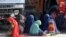 Afghan refugee women and children sit at a registration center after arriving back from Pakistan in Kandahar Province, Afghanistan, late last year. 