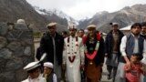 Jaffer Ali Khan, a 31-year-old mason wearing groom's attire, walks with relatives while going to his bride's home during his wedding ceremony in Darkut village in Pakistan on October 13.