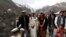 Jaffer Ali Khan, a 31-year-old mason wearing groom's attire, walks with relatives while going to his bride's home during his wedding ceremony in Darkut village in Pakistan on October 13.