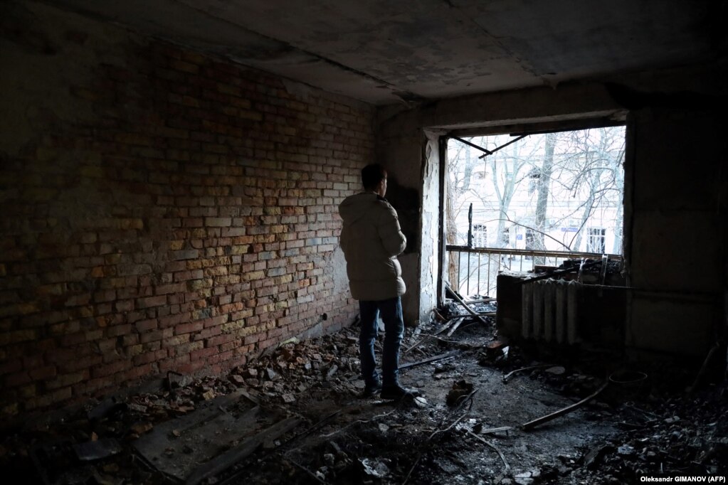 Një banor shikon një apartament të shkatërruar në Odesa.