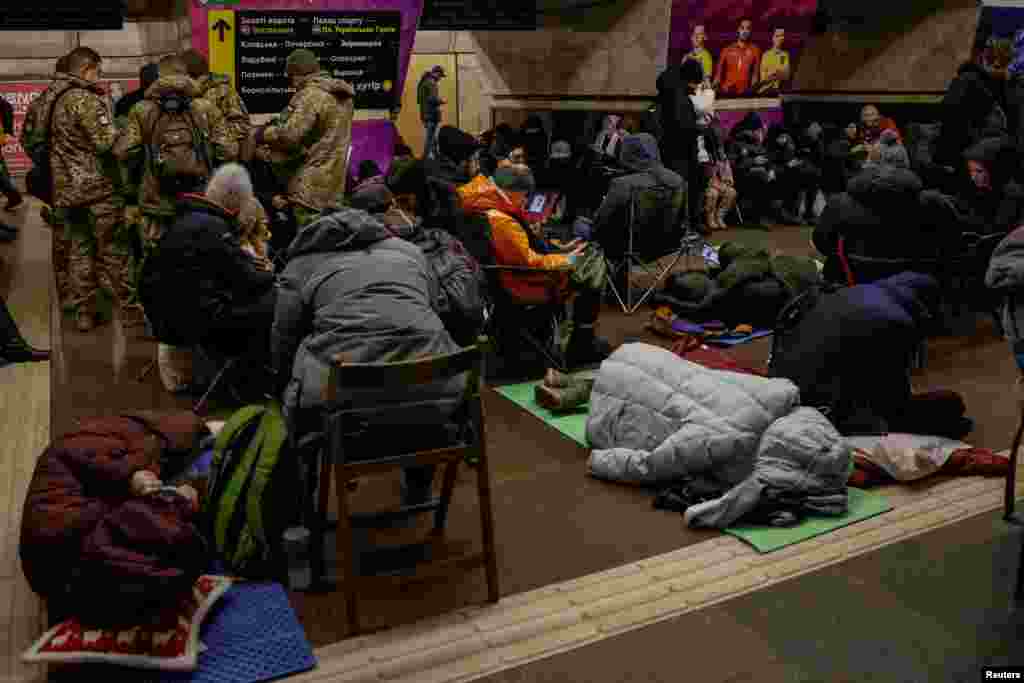 Люди ховаються на станції метро під час повітряної тривоги в Києві 8 січня 2024 року. Україна заявила, що її протиповітряна оборона знищила 18 із 51 ракети, що є меншим показником збиття, ніж зазвичай. Київ пояснює це великою кількістю балістичних ракет, випущених Росією