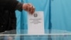 Избиратель опускает бюллетень в урну на выборах депутатов. 19 марта 2023 года