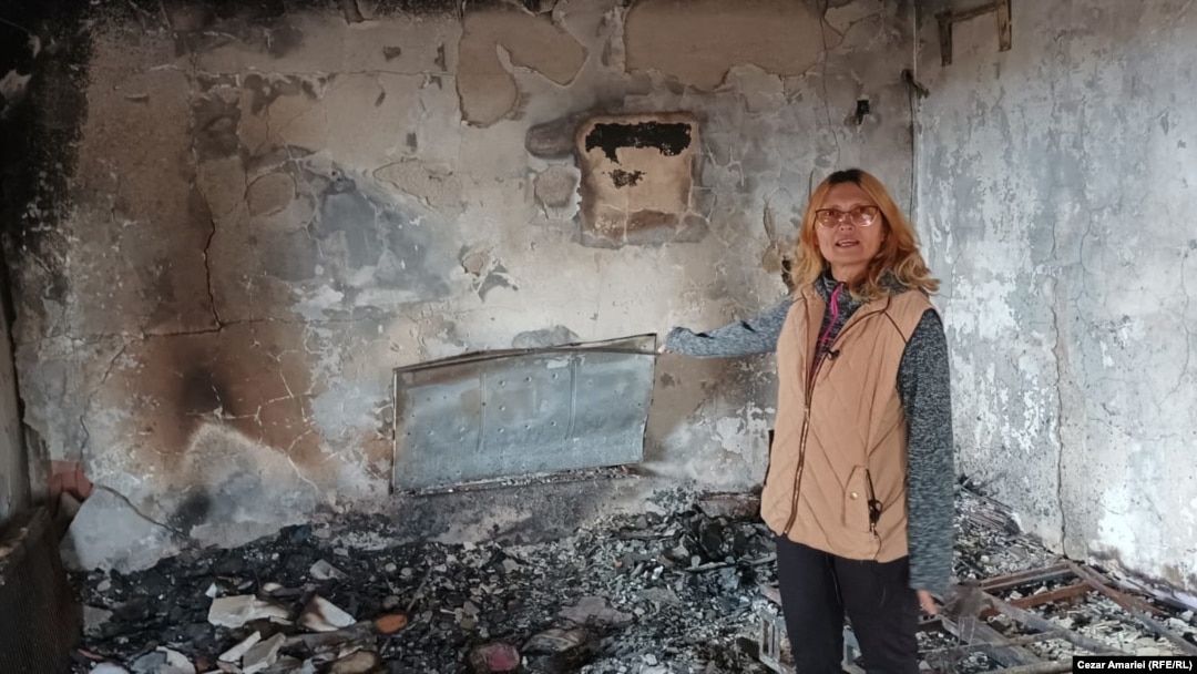 Doina Iliescu, unul dintre cei sinistrați, arată ce a mai rămas din sufrageria casei afectate de explozia din Crevedia. În cel mai bun caz, speră să fie despăgubită în doi ani, timp în care trebuie să se descurce cum poate.