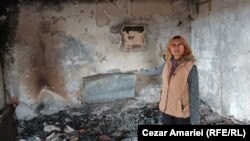 Doina Iliescu, unul dintre cei sinistrați, arată ce a mai rămas din sufrageria casei afectate de explozia din Crevedia. În cel mai bun caz, speră să fie despăgubită în doi ani, timp în care trebuie să se descurce cum poate.