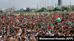 Йеменские мусульмане с палестинскими флагами на пятничной полуденной молитве демонстрируют солидарность с жителями сектора Газа и Западного берега реки Иордан. Контролируемая хуситами столица Йемена Сана, 27 октября 2023 года