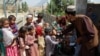 An Afghan health worker administers polio vaccine drops to children during a polio vaccination campaign in Kandahar.