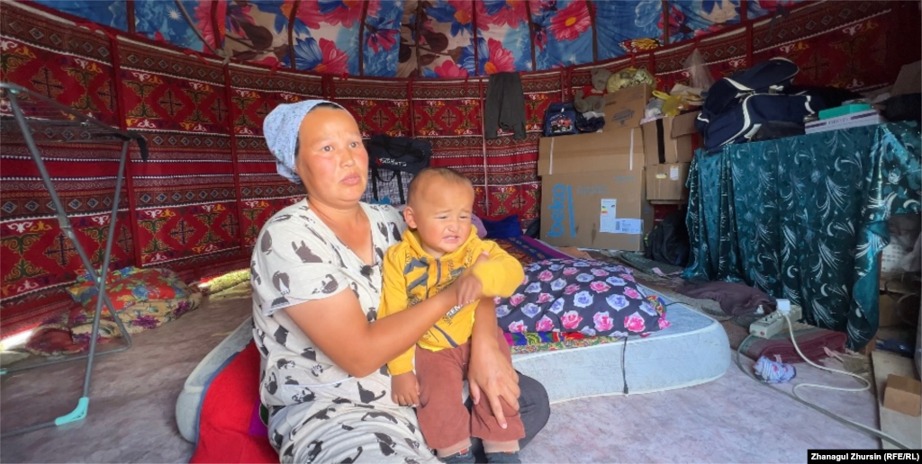 Tolkyn Akhmetova and her child have been living in this yurt for five months. She suffers from leg cramps from the cold and is concerned about her future. The reconstruction of her house stopped three weeks ago after construction workers gathered their belongings and just left.