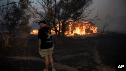 O casă este în flăcări în satul Varnava, la nord de Atena, 11 august 2024. În mai multe regiuni din Grecia a fost declarată stare de alertă maximă din cauza riscului sporit de incendii.