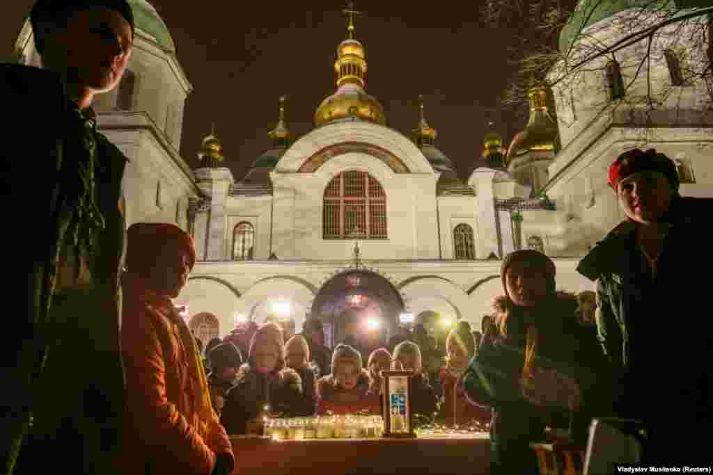 Young Ukrainians surround the lantern, in which the &quot;peace light of Bethlehem&quot; arrived in Kyiv from the Middle East via Austria.&nbsp;