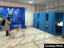 Наблюдатель от миссии ОБСЕ по наблюдению за выборами осматривает урну для голосования, 19 марта 2023 года