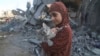 Palestinska djevojčica spašava svoju mačku iz ruševina uništenih zgrada nakon izraelskih zračnih napada u Rafi, južnom pojasu Gaze, srijeda, 18. oktobra 2023.