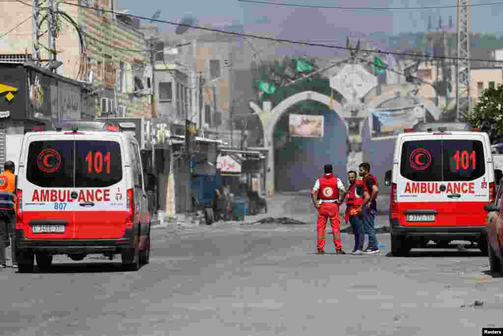 Mjekët palestinezë me autoambulanca shihen në rrugë mes tymit që kapluar qytetin.