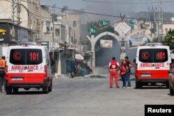 Ambulanțele palestinene așteaptă să transporte răniții din Jenin, 3 iulie.
