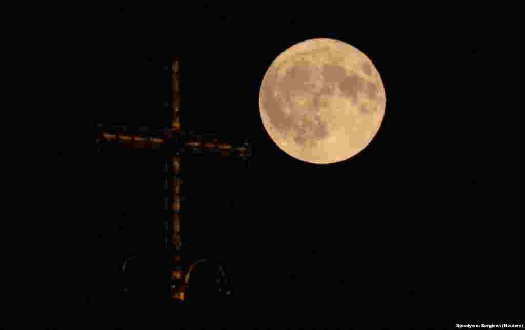 BULGARIA -- A supermoon, known as the blue moon and "Sturgeon Moon", rises over the Alexander Nevsky cathedral in Sofia, Bulgaria, August 19, 2024. 