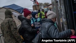 Ukrán menekültek buszra szállnak a lengyel–ukrán határon lévő Medykában 2022. április 1-jén