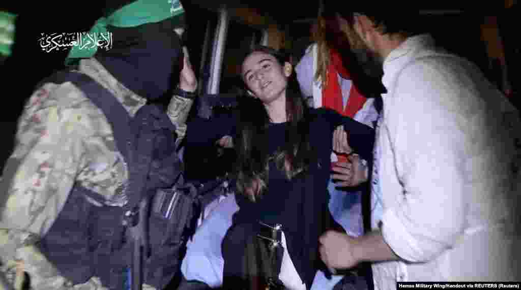 A Hamász fegyveresei átadnak egy túszt a Vöröskereszt Nemzetközi Bizottság tagjainak a Hamász és Izrael között kötött túsz- és fogolycsere-egyezmény részeként a Gázai övezet egy meg nem nevezett helyén egy 2023. november 26-án közzétett videófelvételen.&nbsp;A palesztin fegyveres csoport által szabadon engedett túszok közül tizenhárom izraeli, három thaiföldi és egy orosz állampolgárságú