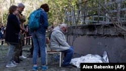 Relatives mourn near the body of a child killed during after a Russian strike on Kyiv earlier this month. 