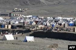 Afghan refugees sit outside their tents at a makeshift camp upon their arrival from Pakistan near the Afghanistan-Pakistan Torkham border in Nangarhar Province on November 12.