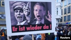 Një pankartë me portretin e ish-ministrit të propagandës naziste Joseph Goebbels dhe Bjoern Hoecke (djathtas), kandidat i AfD-së në zgjedhjet në Thuringia, gjatë një proteste kundër racizmit dhe planeve për dëbimin e migrantëve, në Bon, Gjermani, 21 janar 2024.