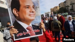 Pristalica drži sliku predsjednika Al Sisija prvog dana predsjedničkih izbora u Egiptu, Kairo, 10. decembra 2023.