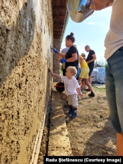 Vullnetarët duke lyer pjesën e jashtme të shtëpisë Casa Frusina.