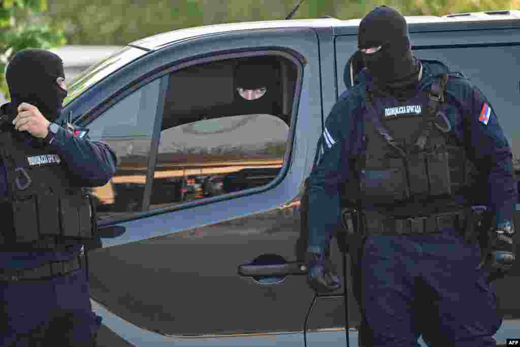 Maszkos rendőrök biztosítják a területet a Belgrádtól mintegy 60 kilométerre lévő Dubona településen, a május 4-i autós lövöldözés egyik helyszínén. Szerbiában május 5-én kora reggel hajtóvadászat indult, miután egy fegyveres legalább nyolc embert megölt és tizennégyet megsebesített, ami a héten a második tömeges lövöldözés volt a balkáni országban.