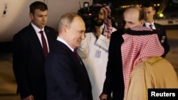 Russian President Vladimir Putin is greeted upon arrival at the airport in Riyadh on December 6.