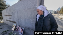 Женщина у камня, к которому родственники погибших во время Январских событий принесли их портреты. Алматы, 5 января 2023 года. На мемориале в центре города, сооружённом к первой годовщине Кровавого января, нет ни фамилий, ни фотографий жертв