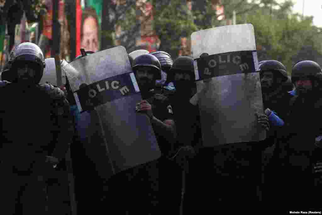 Video images released by PTI showed police striking Khan supporters with batons and lobbing tear-gas canisters, some of which landed on the lawn of Khan&#39;s house, while Khan&#39;s supporters hurled rocks and bricks at the officers.