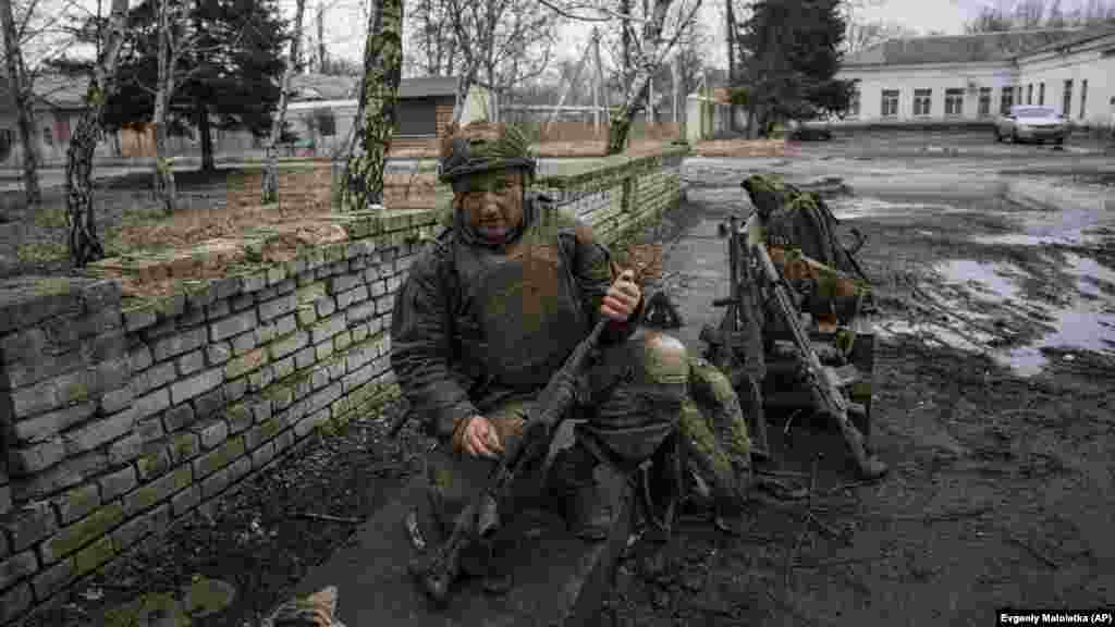 A bahmuti frontvonalról érkezett ukrán katona tisztítja fegyverét Csasziv Jarban