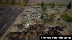 An aerial photo shows freshly dug graves at the cemetery in the village of Hroza, near Kharkiv, where at least 55 people were killed in a missile attack on October 5. 