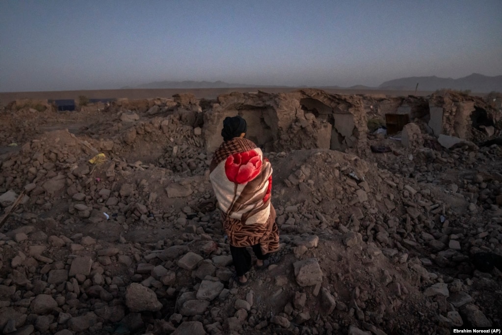 Un uomo afghano cerca vittime nel crepuscolo.  Il portavoce dell'autorità per i disastri, Mohammad Abdullah Jan, ha detto che quattro villaggi nel distretto di Zindah Jan, nella provincia di Herat, hanno subito il peso maggiore del terremoto e delle scosse di assestamento.