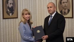 Bulgarian President Rumen Radev (right) hands a mandate to form a government to Goritsa Grancharova-Kozhareva in Sofia on August 9.