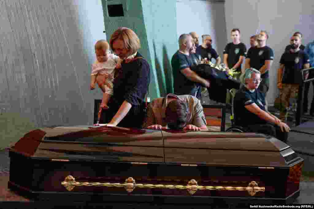 Mourners grieve by Mulkevych&#39;s casket.