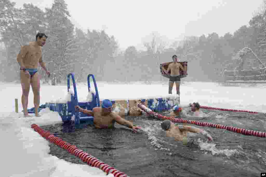 Ljudi plivaju u ledenoj vodi povodom otvaranja 65. zimske plivačke sezone moskovskog kluba Morž u Serebrjanom Boru tokom velikih snježnih padavina u Moskvi, 3. decembra.