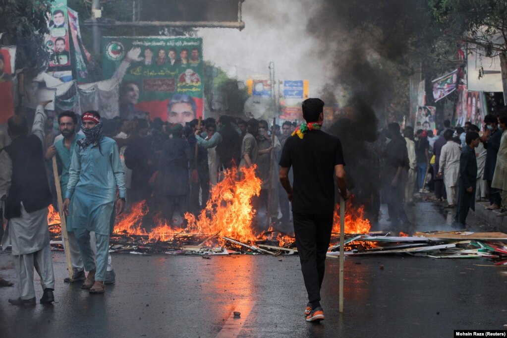 Mbështetësit e ish-kryeministrit pakistanez, Imran Khan, ndezën një zjarr për të bllokuar rrugën gjatë përleshjeve me policinë përpara arrestimit të mundshëm të Khanit jashtë shtëpisë së tij, në Lahore më 14 mars.