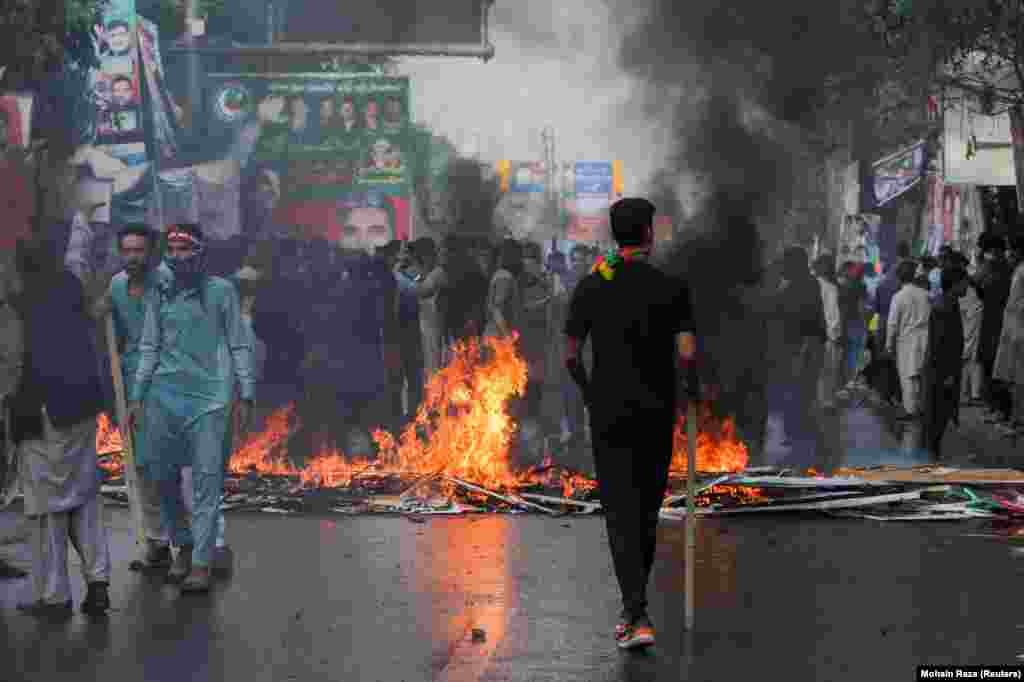 Supporters of former Pakistani Prime Minister Imran Khan started a fire to block the road during clashes with police ahead of Khan&#39;s possible arrest outside his home, in Lahore on March 14.