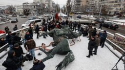 Workers dismantle the monument to Bolshevik military commander Mykola Shchors in Kyiv on December 9.