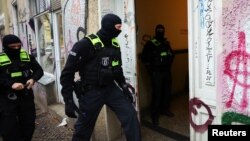 Një oficer i policisë gjermane duke hyrë në një ndërtesë apartamentesh gjatë një bastisjeje kundër njerëzve që mbështesin Hamasin. Berlin, 23 nëntor 2023.