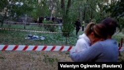 Gyászolók az orosz rakétacsapások egyik halálos áldozata mellett Kijevben 2023. június 1-jén