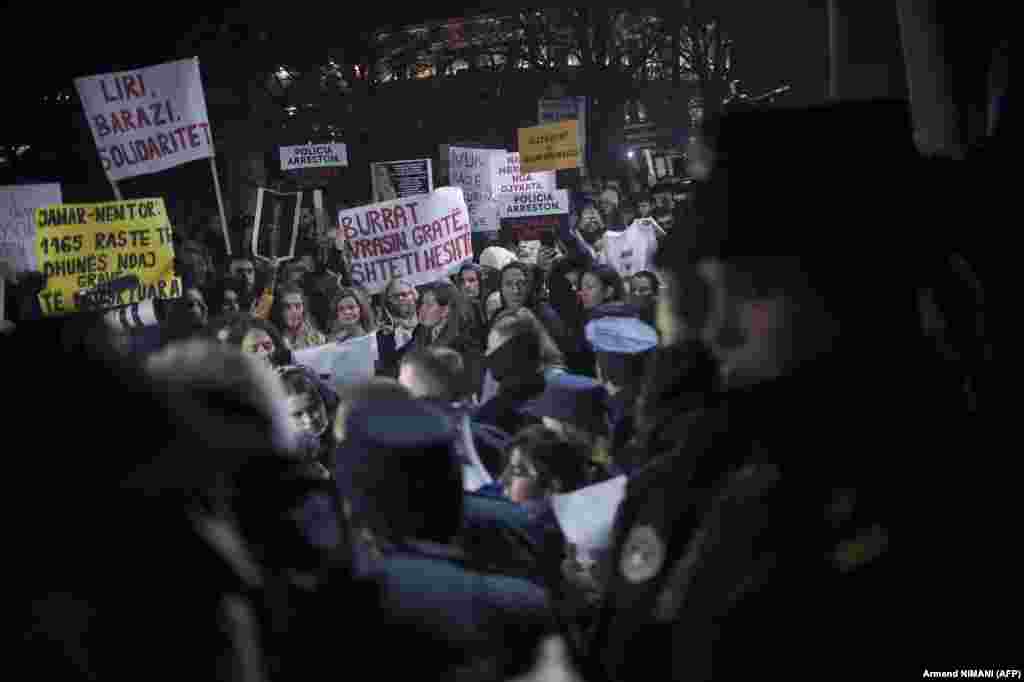 People hold banners and shout slogans as they take part in a demonstration in Pristina against violence against women following the murder of Liridona Ademaj.