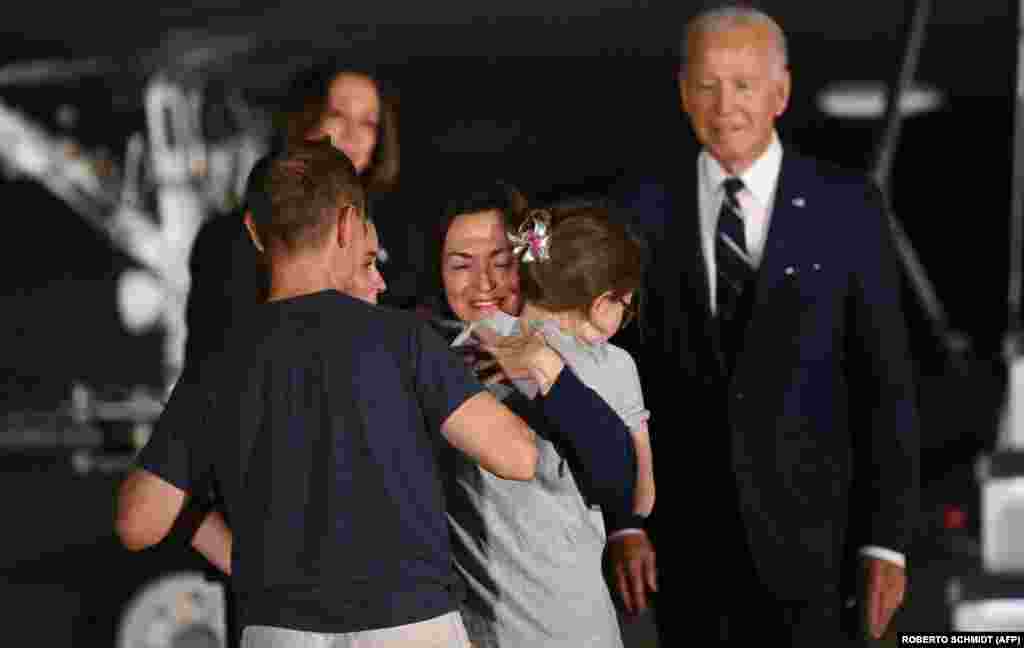 U.S. President Joe Biden and Vice President Kamala Harris watch as RFE/RL journalist Alsu Kurmasehva, a former prisoner held by Russia, embraces her family as she arrives at Joint Base Andrews in Maryland on August 1.&nbsp; Kurmasheva, a 47-year-old mother of two, was arrested in Kazan in October 2023 and first charged with failing to register as a &quot;foreign agent&quot; under a punitive Russian law that targets journalists, civil society activists, and others. She was subsequently charged with spreading falsehoods about the Russian military and sentenced to 6 1/2 years.