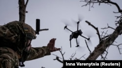 Një ushtar ukrainas duke lëshuar një dron kamikaz të llojit FPV, afër qytetit të Bahmutit në rajonin e Donjeckut. 12 dhjetor 2023. 